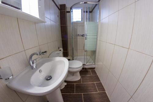 uma casa de banho com um lavatório e um WC em Anthoussa Rooms em Parga