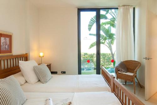 sypialnia z dwoma łóżkami i dużym oknem w obiekcie Salobre Villas w mieście Salobre
