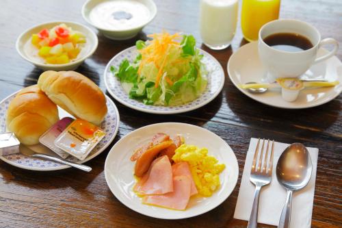 a table with plates of breakfast foods and a cup of coffee at APA Hotel Kumamoto Sakuramachi Bus Terminal Minami in Kumamoto