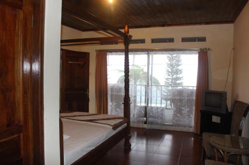 A bed or beds in a room at Sukuh Cottage