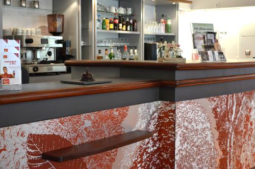 a bar in a restaurant with a reflection in the counter at Hôtel du Parc Nantes Ouest Orvault in Orvault
