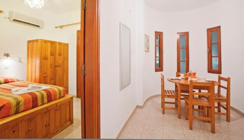a bedroom with a bed and a table and chairs at Pefkos Filoxenia in Pefki Rhodes