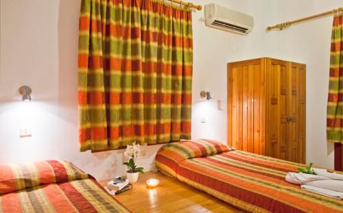 a bedroom with two beds and a window at Pefkos Filoxenia in Pefki Rhodes