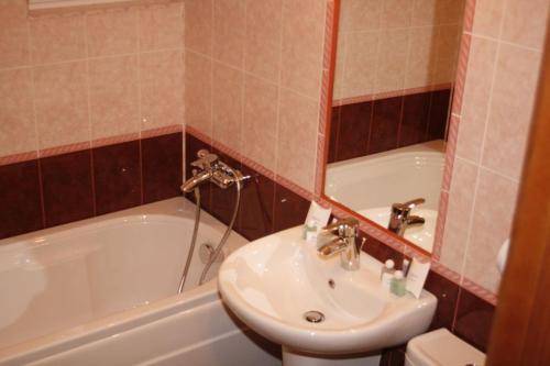 a bathroom with a sink and a tub and a toilet at Hotel Elegance in Asenovgrad