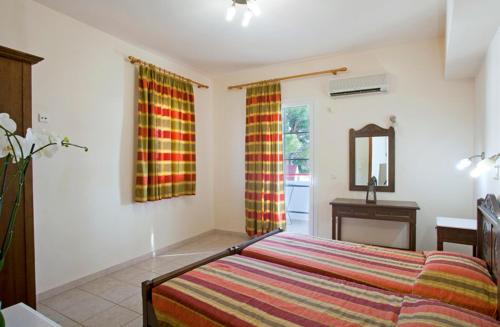 a bedroom with a bed and a table and a mirror at Pefkos Filoxenia in Pefki Rhodes