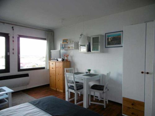 Burgtiefe auf Fehmarn にあるFerienwohnung am Südstrandのベッドルーム1室(テーブル付)、ベッドルーム1室(ベッド1台付)