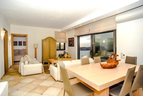 a dining room and living room with a table and chairs at Evexia Villa in Thólos