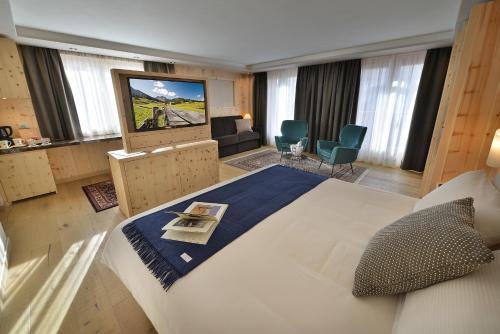 a hotel room with a large bed and a television at Hotel St. Michael in Livigno