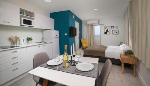 a room with a bed and a dining table and a kitchen at Diana Hotel in Haifa