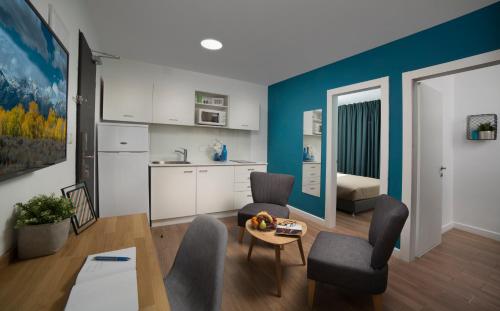 a living room with a table and chairs and a kitchen at Diana Hotel in Haifa