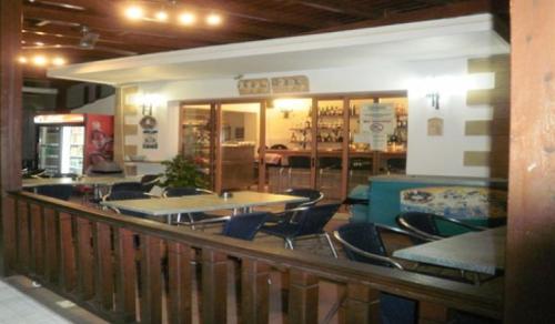 a restaurant with tables and chairs on a balcony at Pefkos Filoxenia in Pefki