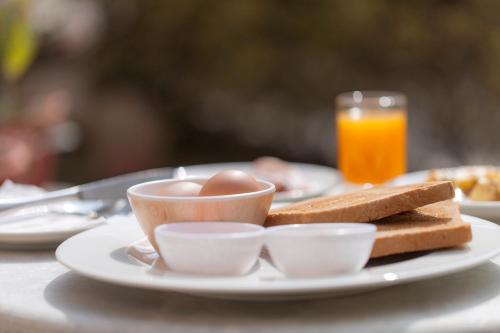 a plate of food with eggs and toast on a table at Shaligram Hotel in Pātan