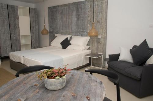 a bedroom with a bed and a table and a couch at Hylatio Tourist Village in Pissouri