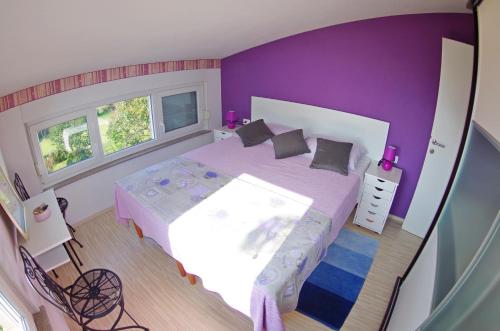una camera da letto con un grande letto con pareti viola di Leni a Fažana