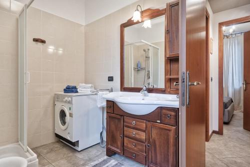 a bathroom with a sink and a washing machine at Moleloca - San Tommaso Apartment in Turin
