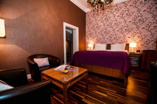 a hotel room with a bed and a table and chairs at Gimo Herrgård in Gimo