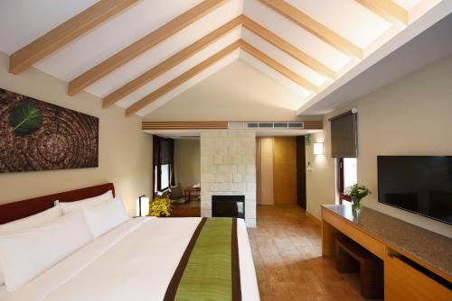 a living room with a large bed and a large window at Fullon Hotel Fulong in Gongliao