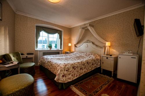 a bedroom with a large bed and a window at Gimo Herrgård in Gimo