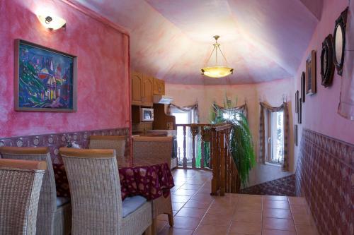 a dining room with pink walls and a table and chairs at Green Park Villa in Eger