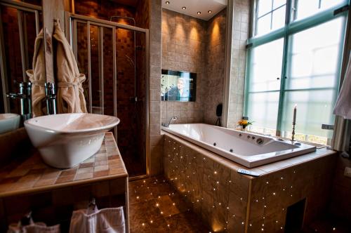 a large bathroom with a tub and a sink at Gimo Herrgård in Gimo