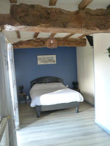 a bedroom with a bed and a wooden floor at Le Marquis De La Guintre in Courtils