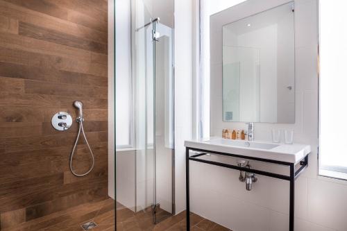 a bathroom with a shower and a sink at Hotel Marais Grands Boulevards in Paris