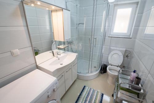a bathroom with a sink and a shower and a toilet at Villa Karamba in Senj