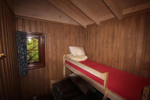 um pequeno quarto com uma cama e uma janela em Bratland Camping em Bergen