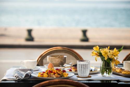 a table with plates of food and a vase of flowers at Daios Luxury Living in Thessaloniki