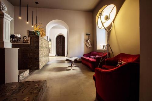 a living room with red couches and a fireplace at Shalai - Exclusive SPA and small gourmet hotel in Linguaglossa