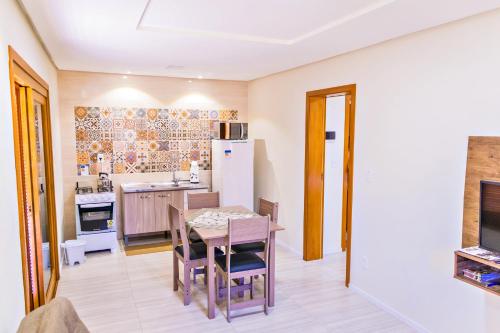 eine Küche mit einem Tisch und Stühlen sowie einem Kühlschrank in der Unterkunft Cantinho do Sossego in Nova Petrópolis