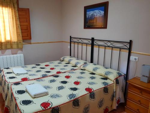 a bedroom with a bed with a flowered blanket at Camping Ruta del Purche in Monachil