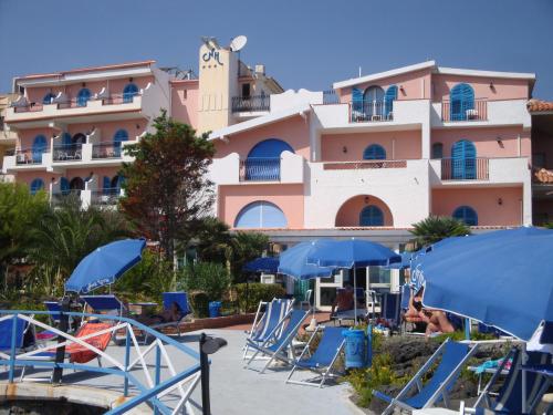 a hotel with chairs and umbrellas in front of it at Hotel Nike in Giardini Naxos