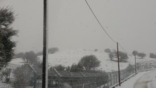 a snow covered field with a fence and a hill at מקום בצפון הגולן - A place in the northern Golan Heights in Merom Golan
