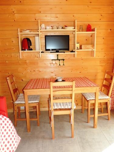 une salle à manger avec une table et des chaises et une télévision dans l'établissement Au Bout du Chemin, à Hohrod