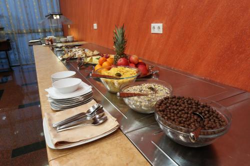 a buffet line with bowls of food and bowls of fruit at Hotel Zenica in Zenica