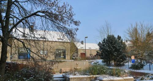 a building with snow on the ground in front of it at Résidence Durbuy in Durbuy