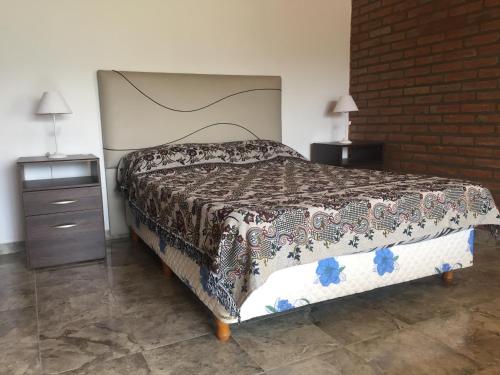 a bedroom with a bed and a brick wall at Complejo M&M in Bialet Massé
