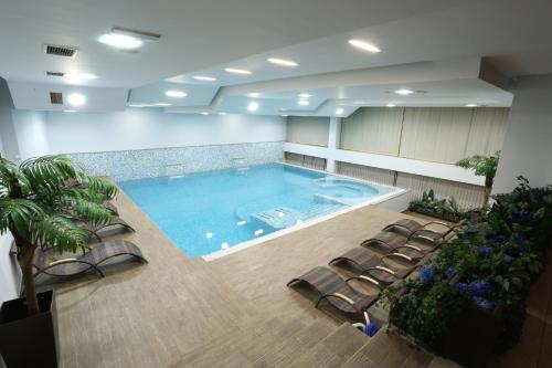 a large swimming pool in a room with chairs at Hotel Zenica in Zenica