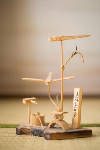 a wooden figurine of a umbrella and two miniature trees at Guest House DOUGO-YADO in Matsuyama