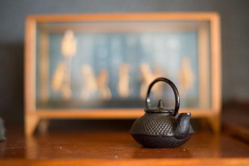 a black tea kettle sitting on a table in front of a television at Guest House DOUGO-YADO in Matsuyama