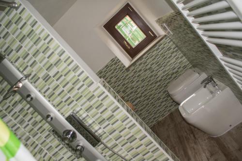 bagno con servizi igienici bianchi e finestra di Antica Dimora del Pellegrino ad Anghiari