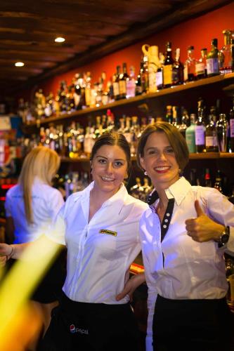 two women standing next to each other in a bar at Šnekolend in Rokytnice nad Jizerou