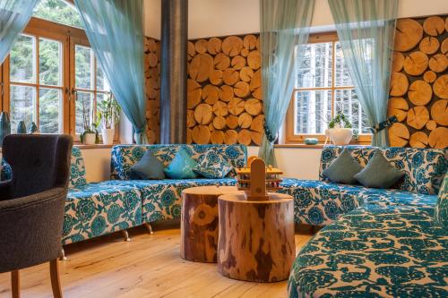 una sala de estar con sofás y un tronco de madera en el medio. en Berghotel Der Königsleitner - Adults only, en Königsleiten