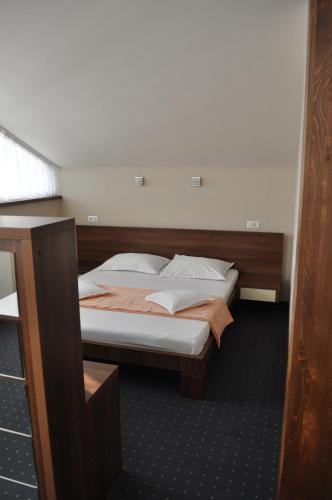 a bedroom with a bed with a wooden headboard at Euro House Hotel in Baia Mare