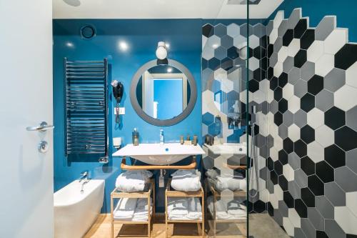 a bathroom with blue walls and a sink and a mirror at Rarity Suites in Rome