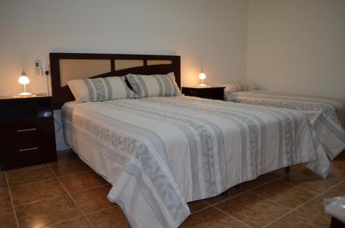 2 camas en un dormitorio con 2 lámparas en las mesas en Departamento Ciudad De Santa Rosa en Santa Rosa