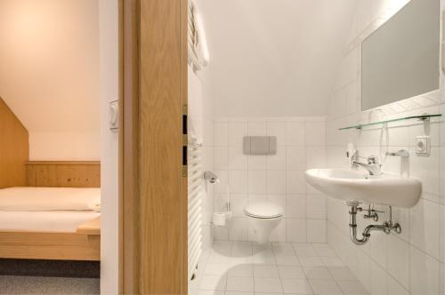 a bathroom with a sink and a toilet at Hotel Gasthof zur Post in Munich