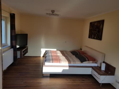 a bedroom with a bed and a flat screen tv at Ferienwohnung Stichauner in Bodensdorf