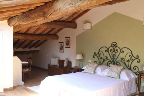 una camera con letto bianco e soffitti in legno di Villa Fillinelle a Tavarnelle in Val di Pesa